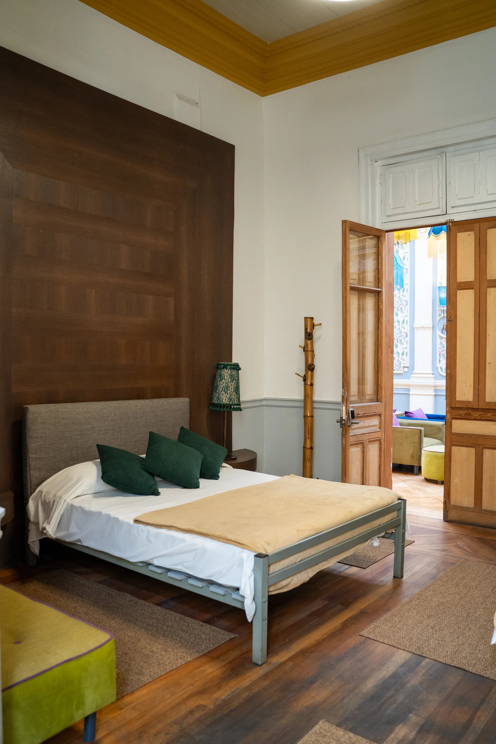 Spacious deluxe triple room at Happy House Santiago for 3 guests with arched windows, geometric parquet and art deco details